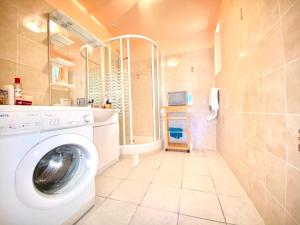 uma lavandaria com uma máquina de lavar roupa na casa de banho em Spacieuse maison dans un parc privée em Vareilles