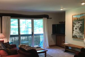 a living room with a couch and a large window at Mountain Breeze Getaway Condos in Warren