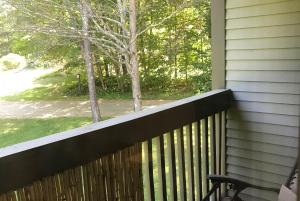 una veranda in legno con panchina su una casa di Mountain Breeze Getaway Condos a Warren