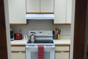 a kitchen with a stove with a tea kettle on it at Mountain Breeze Getaway Condos in Warren