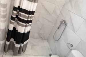 bagno con tenda da doccia in bianco e nero di Panorama View Apartment 2 ad Áyioi Apóstoloi