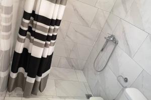 a bathroom with a black and white shower curtain at Panorama View Apartment 2 in Áyioi Apóstoloi