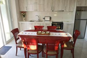 a kitchen with a red dining table and chairs at Panorama View Apartment 2 in Áyioi Apóstoloi