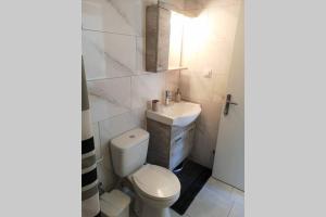 a white bathroom with a toilet and a sink at Panorama View Apartment 2 in Áyioi Apóstoloi