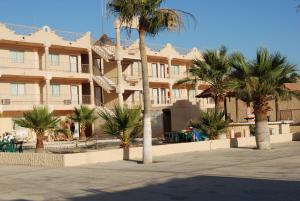 a large building with palm trees in front of it at Hotel Plaza Peñasco in Puerto Peñasco