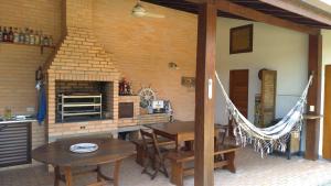un patio con mesa, sillas y chimenea en Suíte Água Branca Residencial Exclusive, en Ilhabela