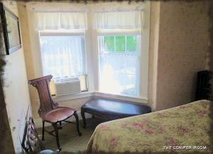 a bedroom with a bed and a chair and a window at Spruce Moose Lodge in North Conway