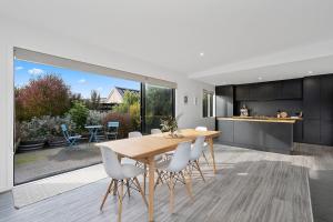 a kitchen and dining room with a wooden table and chairs at Cedar House - Martinborough Holiday Home in Martinborough 