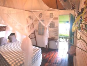Schlafzimmer mit einem Bett mit Moskitonetz in der Unterkunft Kohchang 7 Guest House in Ko Chang