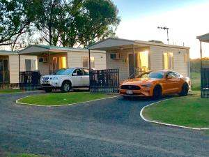 une voiture orange garée devant une maison dans l'établissement Crows Nest Tourist Park, à Crows Nest
