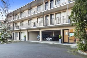 an apartment building with cars parked in the parking lot at Grosvenor Court Apartments in Hobart