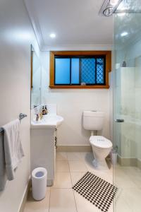 a bathroom with a toilet and a sink and a shower at The Village B&B in Gold Coast