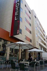two tables with umbrellas in front of a hotel at Zenit Dos Infantas in Zamora