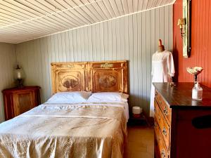 a bedroom with a bed with a wooden dresser and a dresser at Relais Borgo Poggetello in Tagliacozzo