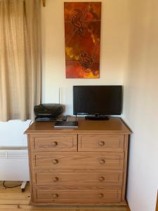 a wooden dresser with a television on top of it at Moana Beach Sunset Holiday Accommodation A in Moana