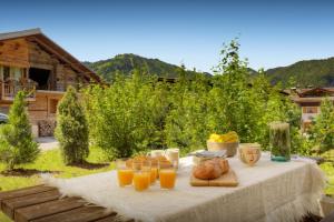 een tafel met een glas sinaasappelsap en brood erop bij Chalet Edenalpa - OVO Network in La Clusaz