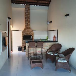 una cocina con sillas y un bar con chimenea en Bela Casa na Praia de Águas Belas, en Caponga