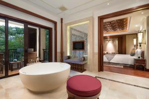 a bathroom with a tub and a bedroom with a bed at InterContinental Xishuangbanna Resort, an IHG Hotel in Jinghong