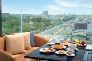 een tafel met eten erop met uitzicht op de stad bij Holiday Inn & Suites Siracha Laemchabang, an IHG Hotel in Si Racha