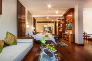 a hotel room with a bed and a living room at Borei Angkor Resort & Spa in Siem Reap