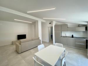 un soggiorno con tavolo bianco e divano di EM Apartments a Lignano Sabbiadoro