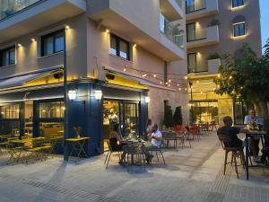 a group of people sitting at tables outside of a building at Old Port Hotel in Limassol