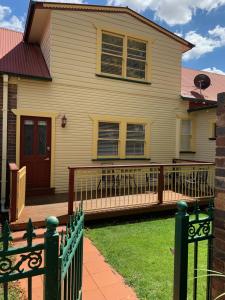 a house with a green fence in front of it at City Center - Comfortable 2-Bedroom Apartment in Armidale