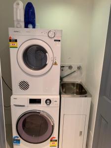 a washing machine and a sink in a room at City Center - Comfortable 2-Bedroom Apartment in Armidale