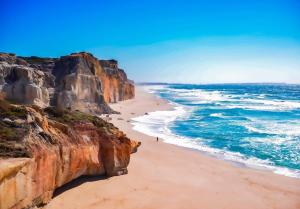 a view of a beach with cliffs and the ocean at Surfness Lodge in Baleal