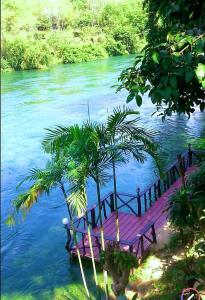 a wooden bridge in the middle of a river at Baan Pak Rim Kuaen Resort in Ratchaprapha