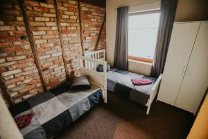1 dormitorio con 2 literas y pared de ladrillo en Salas Holiday Home, en Jūrkalne