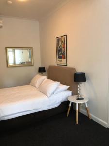 1 dormitorio con cama y mesa pequeña en Hotel 59 Sydney en Sídney