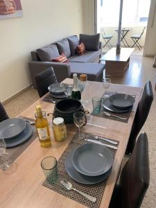 - une table en bois avec des assiettes et des verres à vin dans l'établissement City Comfortable Apartment, à Larnaka