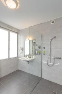 La salle de bains est pourvue d'une douche en verre et d'un lavabo. dans l'établissement Hôtel Le Vouglans - Restaurant La Valouse, à Orgelet