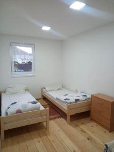 1 dormitorio con 2 camas y ventana en ubytovanie Petra, en Spišské Tomášovce