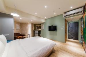 a bedroom with a white bed and a flat screen tv at Talent Hotel E Series in Luodong