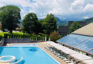 a swimming pool with lounge chairs next to a building at Home away from home in Bohinj