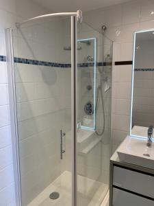 a glass shower in a bathroom with a sink at La Baule Family in La Baule