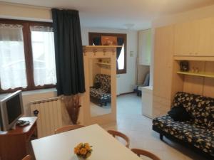 ein Wohnzimmer mit Sofa und Tisch und ein Wohnzimmer in der Unterkunft Val di Luce Home in Abetone