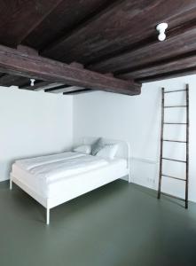 a white room with a bed and a ladder at CHARMANTES APARTMENT im Herzen von Linz in Linz