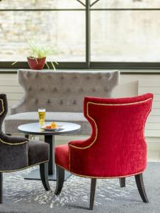 - un salon avec deux chaises et une table dans l'établissement Hôtel Le Vouglans - Restaurant La Valouse, à Orgelet