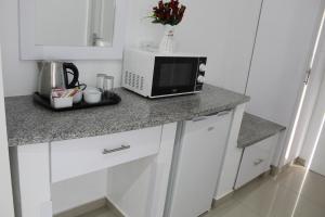 una cucina con forno a microonde su un bancone di Royal Ushaka Hotel Morningside a Durban