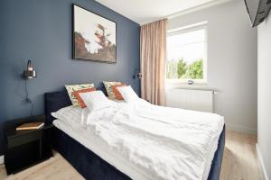 奥尔什丁Apartament Dwa Jeziora的卧室里有一张铺着白色床单的大床