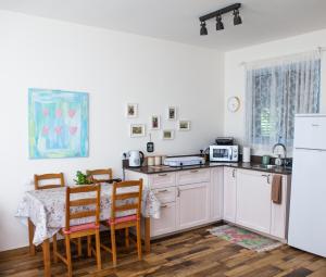 a kitchen with white cabinets and a table with chairs at Olive - Israeli Zimmer in Beit Hillel