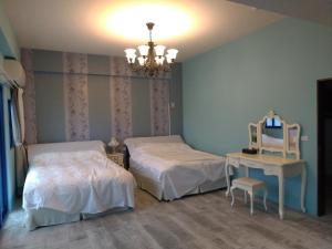 a bedroom with two beds and a mirror and a chandelier at 蓋雅之都民宿 民宿編號1468號 in Taitung City