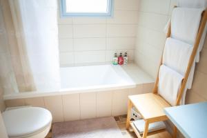 a bathroom with a toilet and a bath tub at Olive - Israeli Zimmer in Bet Hillel +55 photos