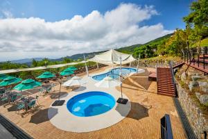 una piscina al aire libre con sombrillas y sombrillas en Gyeongju Mauna Ocean Resort, en Gyeongju