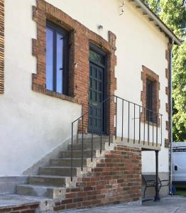 uma casa de tijolos com uma porta verde e escadas em Moon River em Saint-Junien