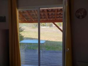a patio door with a table on a deck at CÉVENNES MAISONNETTE DANS RÉSIDENCE DE VACANCES in Sauve