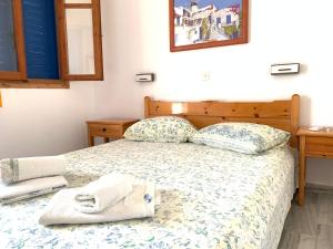 a bedroom with a bed with towels on it at Prombona Petrino Spiti Studios in Piso Livadi